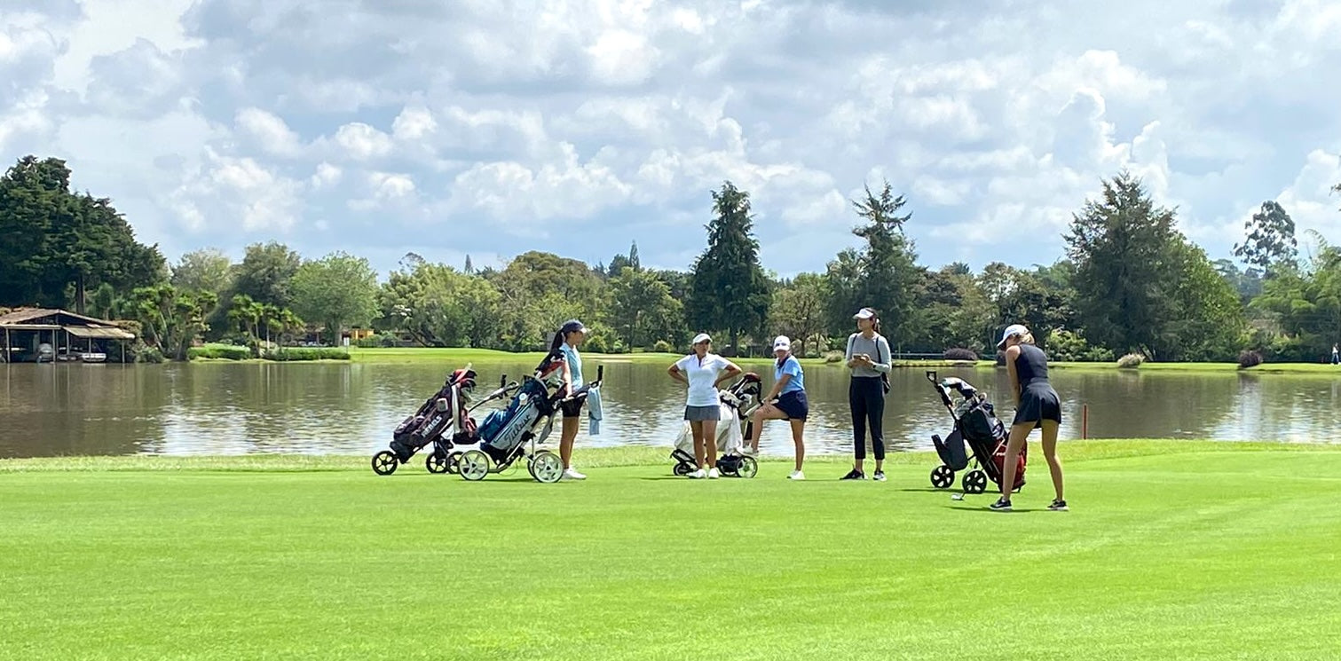 Junior girl golfers on a tournament on a sunny golf course, highlighting the need for sun protection during long hours on the green